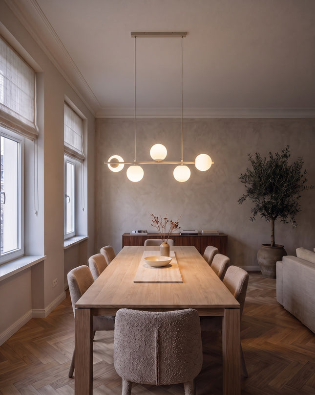 Cinque linear pendant light in beige with five opal glass globes above a dining table