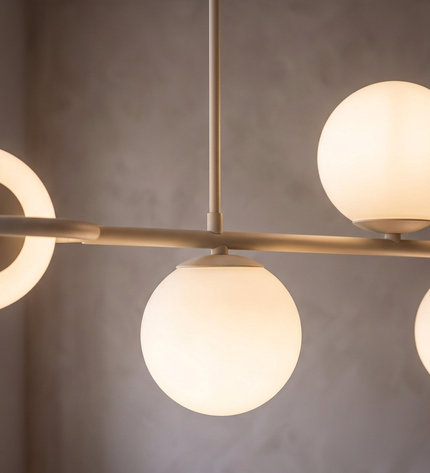 Cinque pendant light close-up: opal glass globes on a slim beige bar