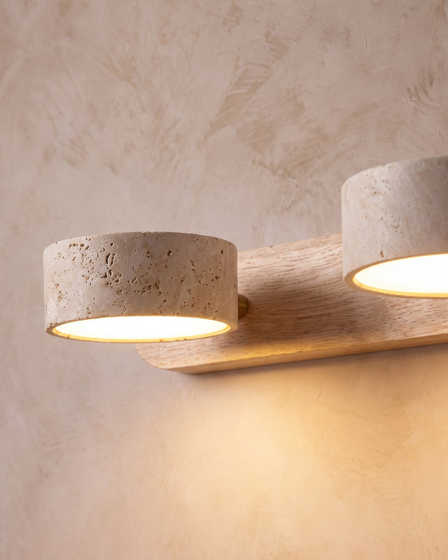 Cava wall light close-up: porous travertine shades on an oak backplate