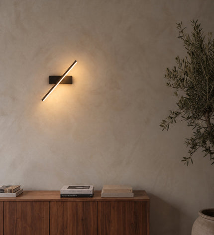 Rome LED wall light in black on a lime plaster wall