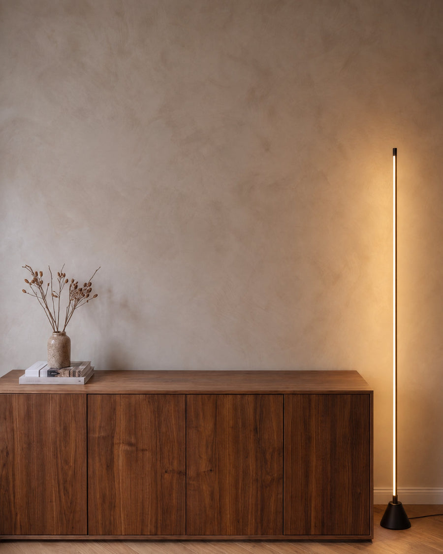 Tero floor lamp with LED light bar next to a sideboard