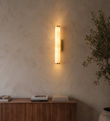 Klyr wall light in brass and white on a lime plaster wall