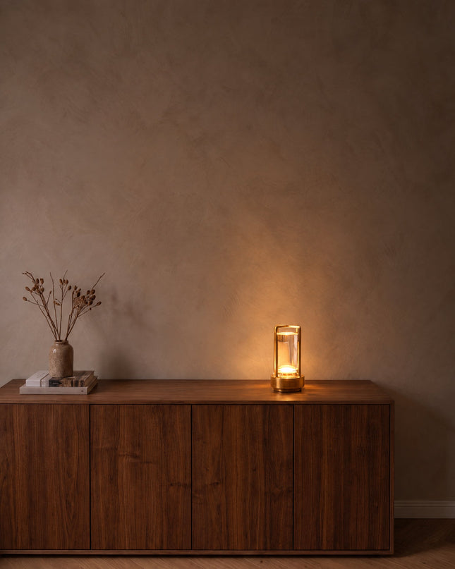 Gemma cordless crystal lantern lamp in gold, glowing on a walnut sideboard