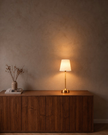 Sera cordless table lamp with fabric shade and gold stem on a walnut sideboard