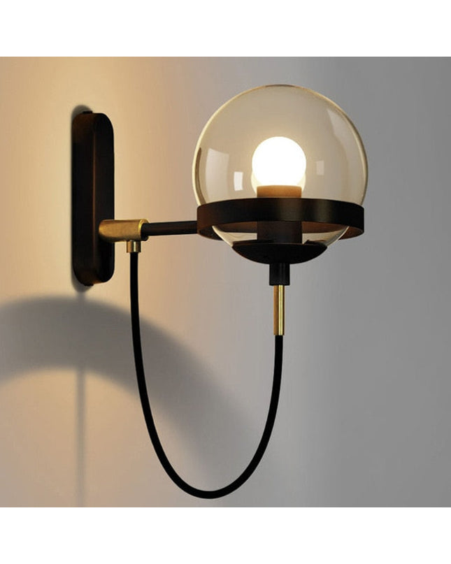 Black Strasbourg wall light by Kezaro with a sleek, modern design and cylindrical shape, mounted on a white wall.