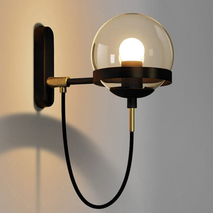 Black Strasbourg wall light by Kezaro with a sleek, modern design and cylindrical shape, mounted on a white wall.